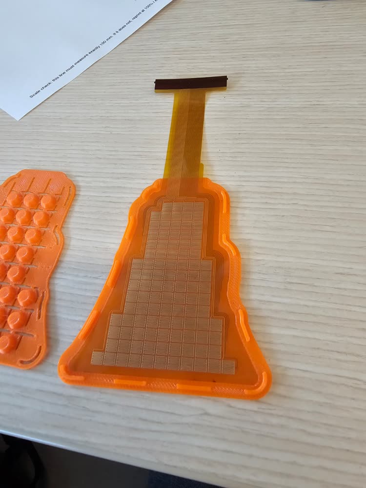 The flex PCB sitting in the pocket of the tray, taxels up.